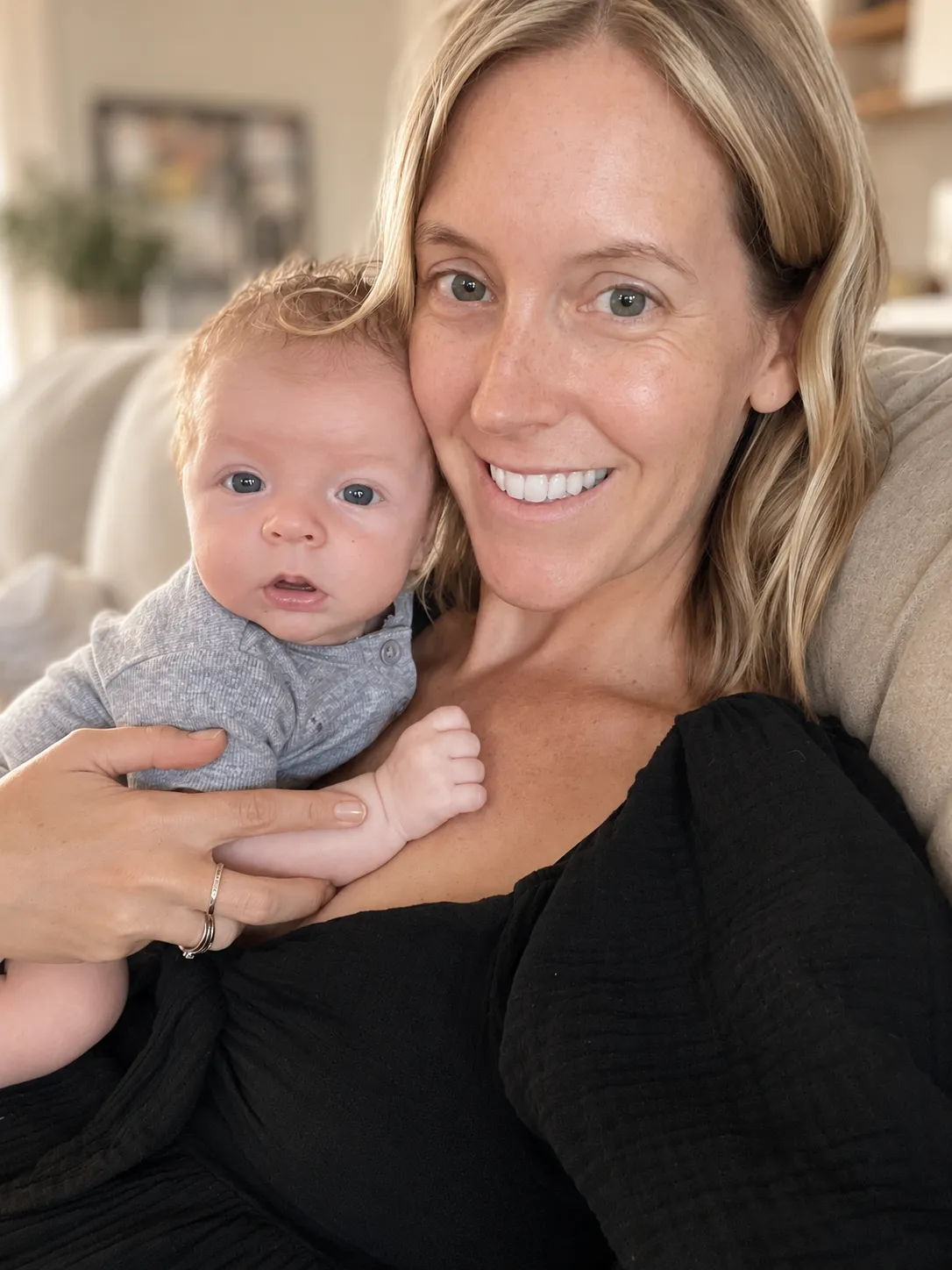 Elly, Certified Infant and Child Sleep Consultant at Baby Sleep Collective, holding a newborn baby.