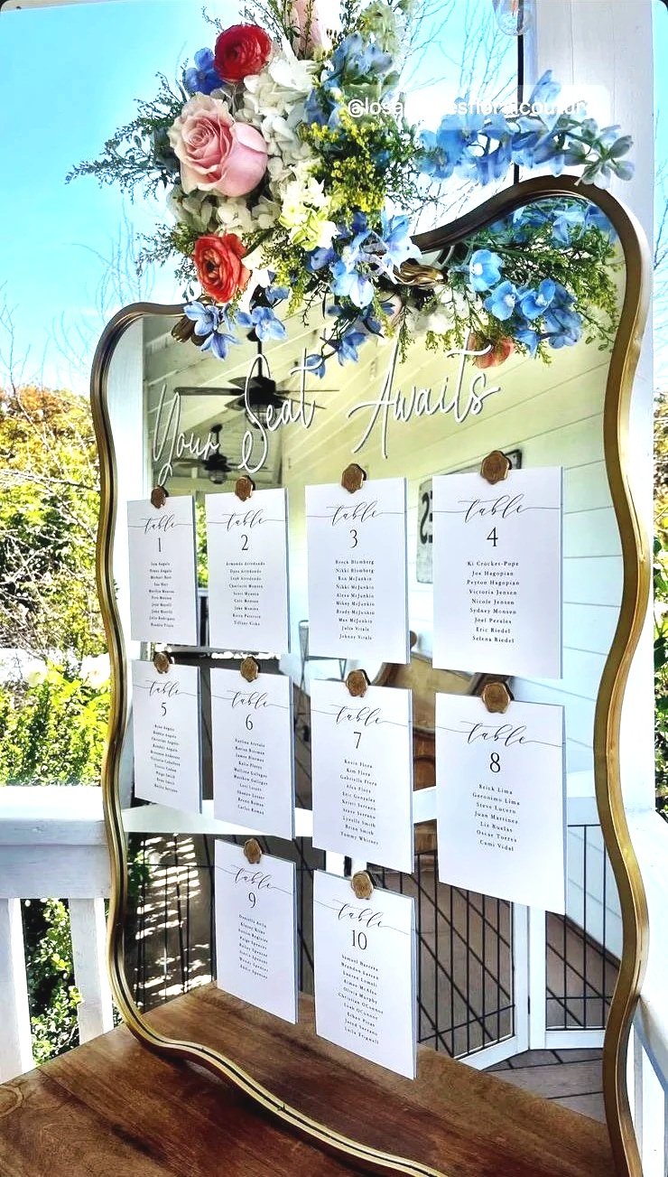 A hand-lettered mirror welcome sign installed at a wedding entrance
