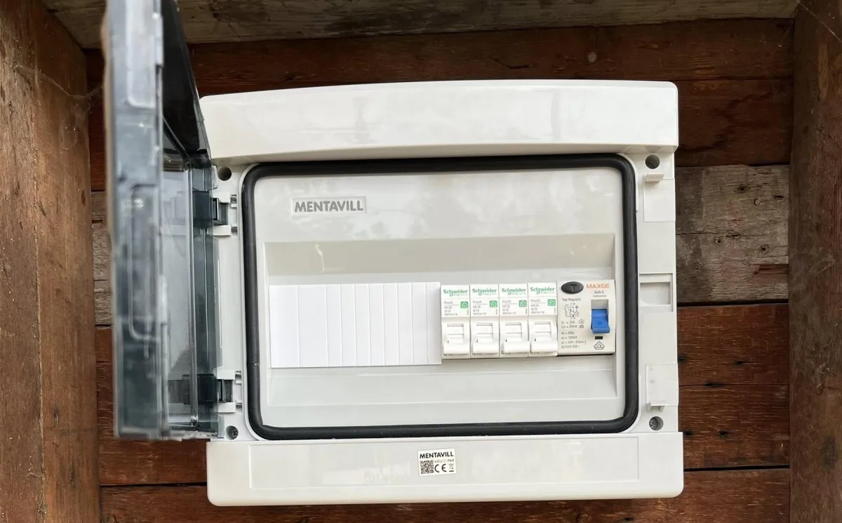 A white hose is coiled and hung on a wall.