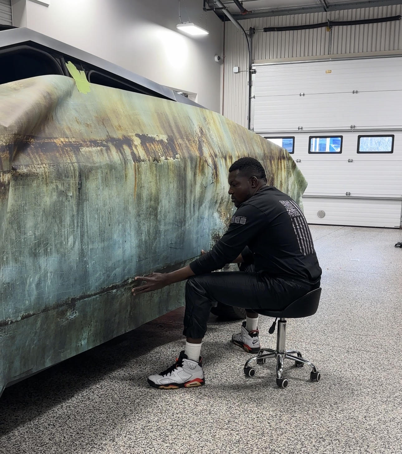 Car Toyz Vinyl Technician applying "rusty" wrap to Cyber Truck