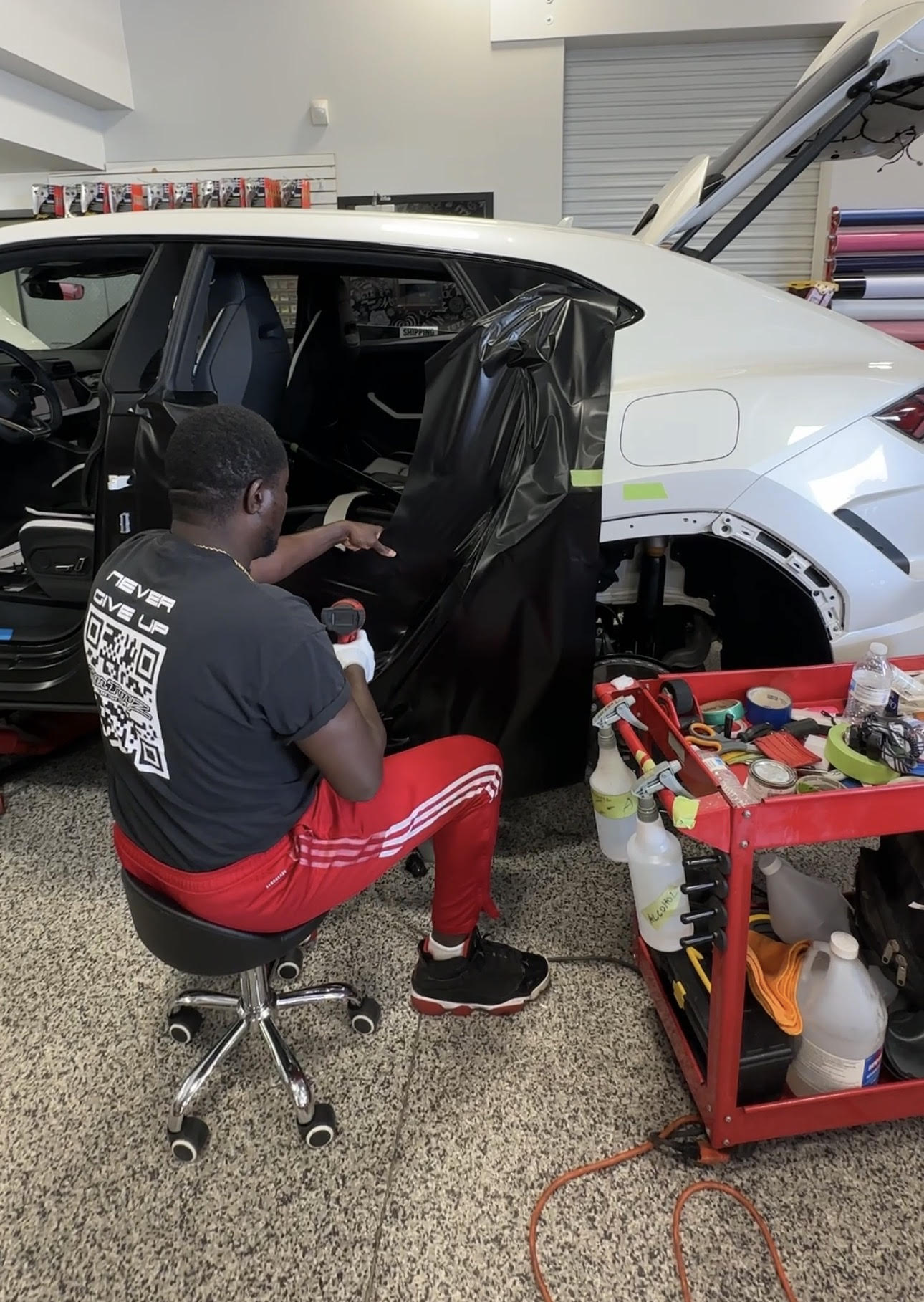 Car Toyz Vinyl Technician Applying the matte black wrap to a 2025 Lamborghini Urus