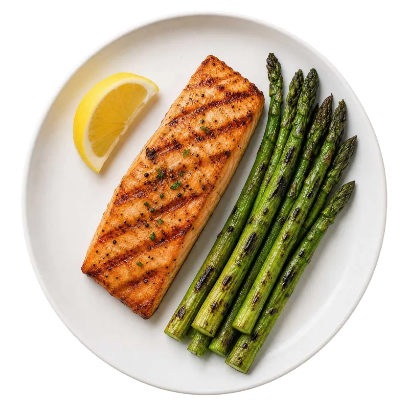 A grilled salmon fillet with asparagus and a lemon wedge on a white plate, representing a protocol-approved Ideal Protein dinner meal