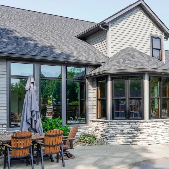 A light gray house by a body of water