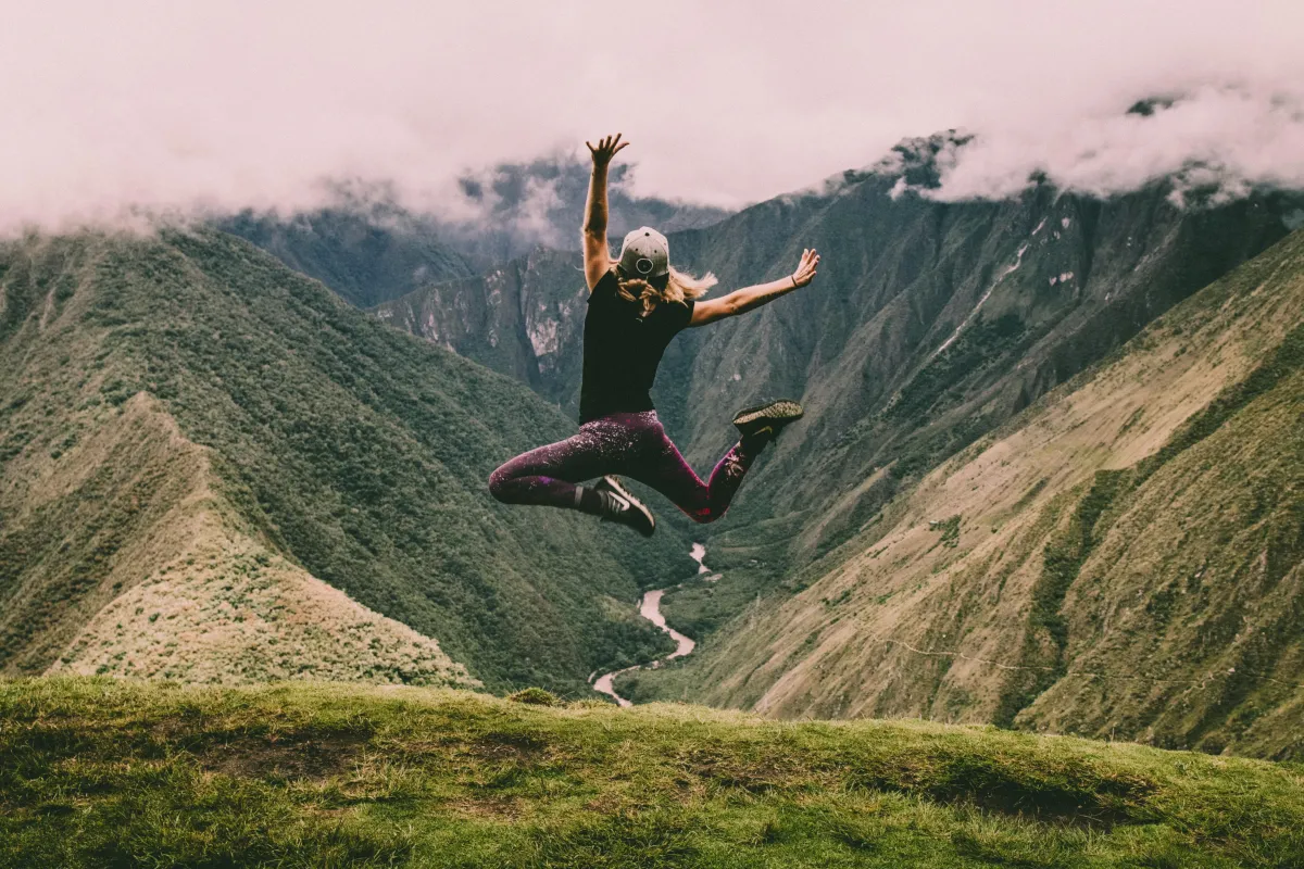happy and healthy woman jumping in the mountains