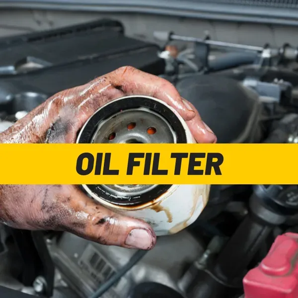 Mechanic's oily hand holding a used oil filter over a car engine, part of a mobile car service at home