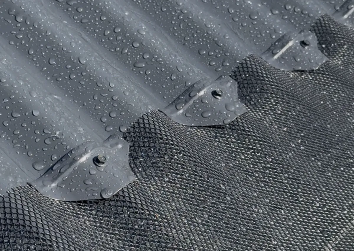 Rain on corrugated roof with gutter guard installed for leaf protection