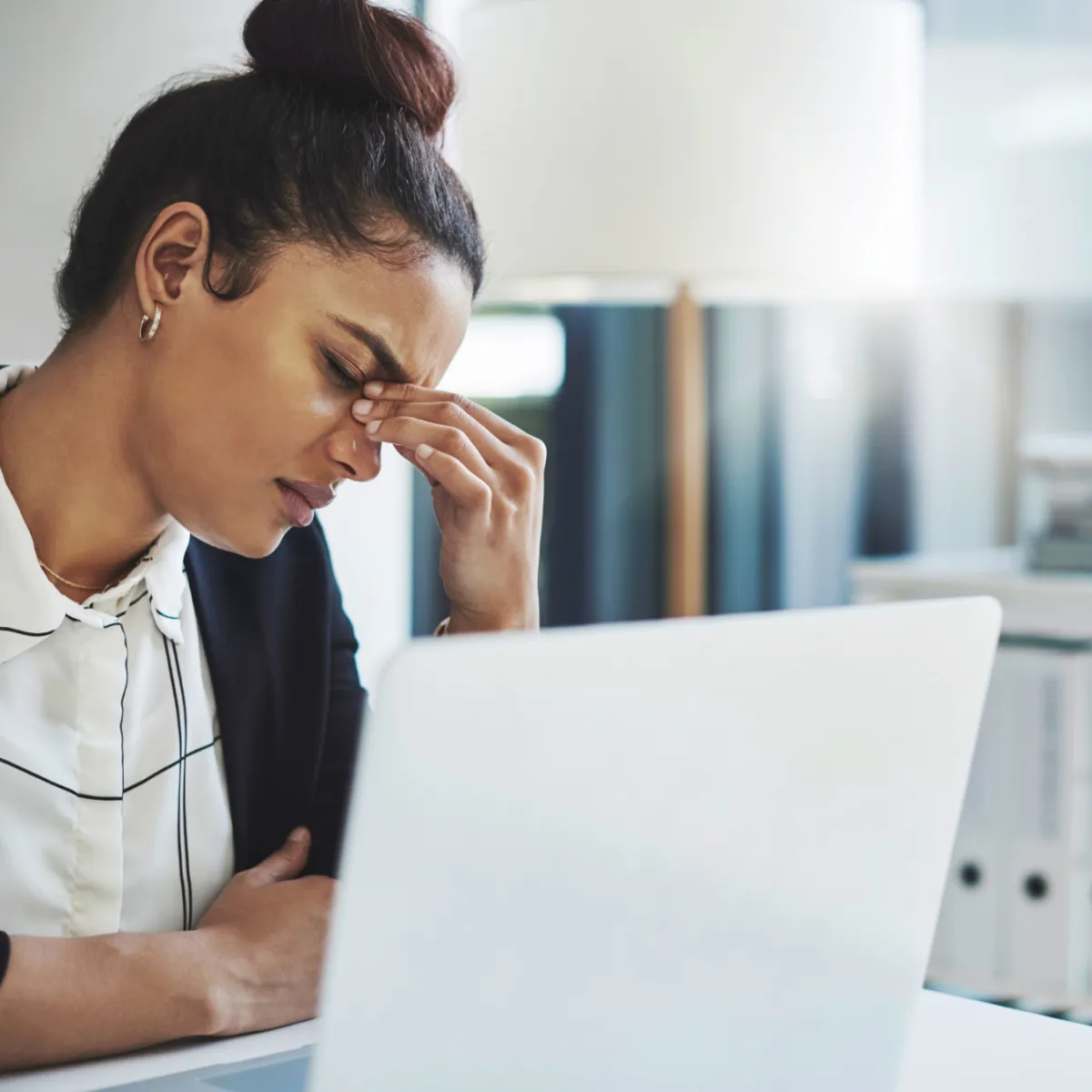 Woman at her desk feeling tired and stressed