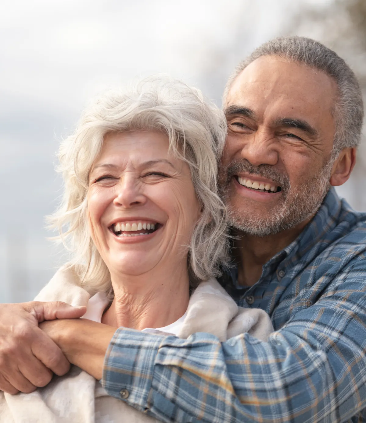 Older male and female hugging and smiling