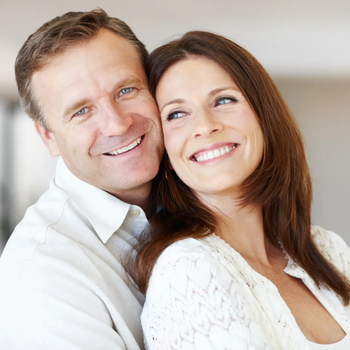 Older women hugging older man while smiling