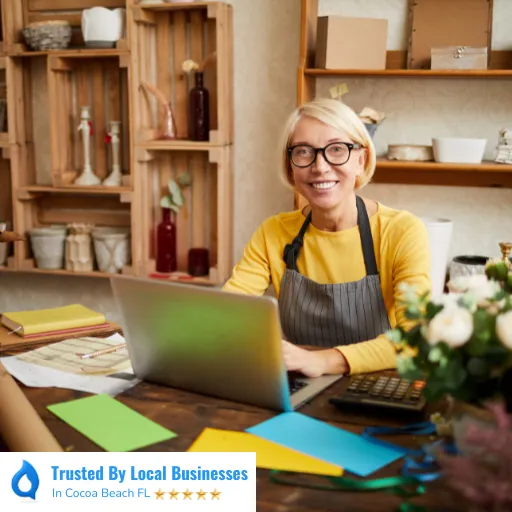 Happy Cocoa Beach business owner sitting confidently inside of their thriving local business after partnering with Living Logos Media for digital marketing services