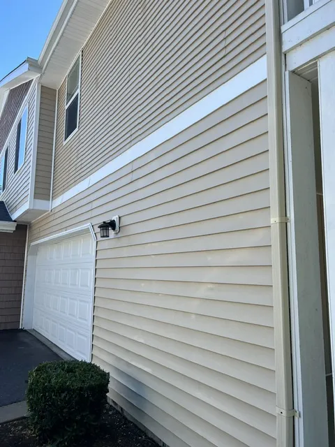 Freshly washed two-story home with cedar shingle siding and a clean covered porch in Olympia, WA