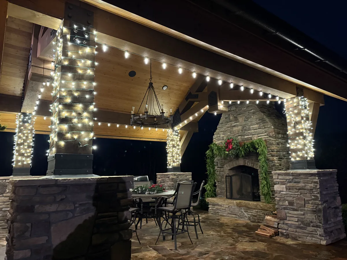 Technician installing Christmas lights on a home exterior.