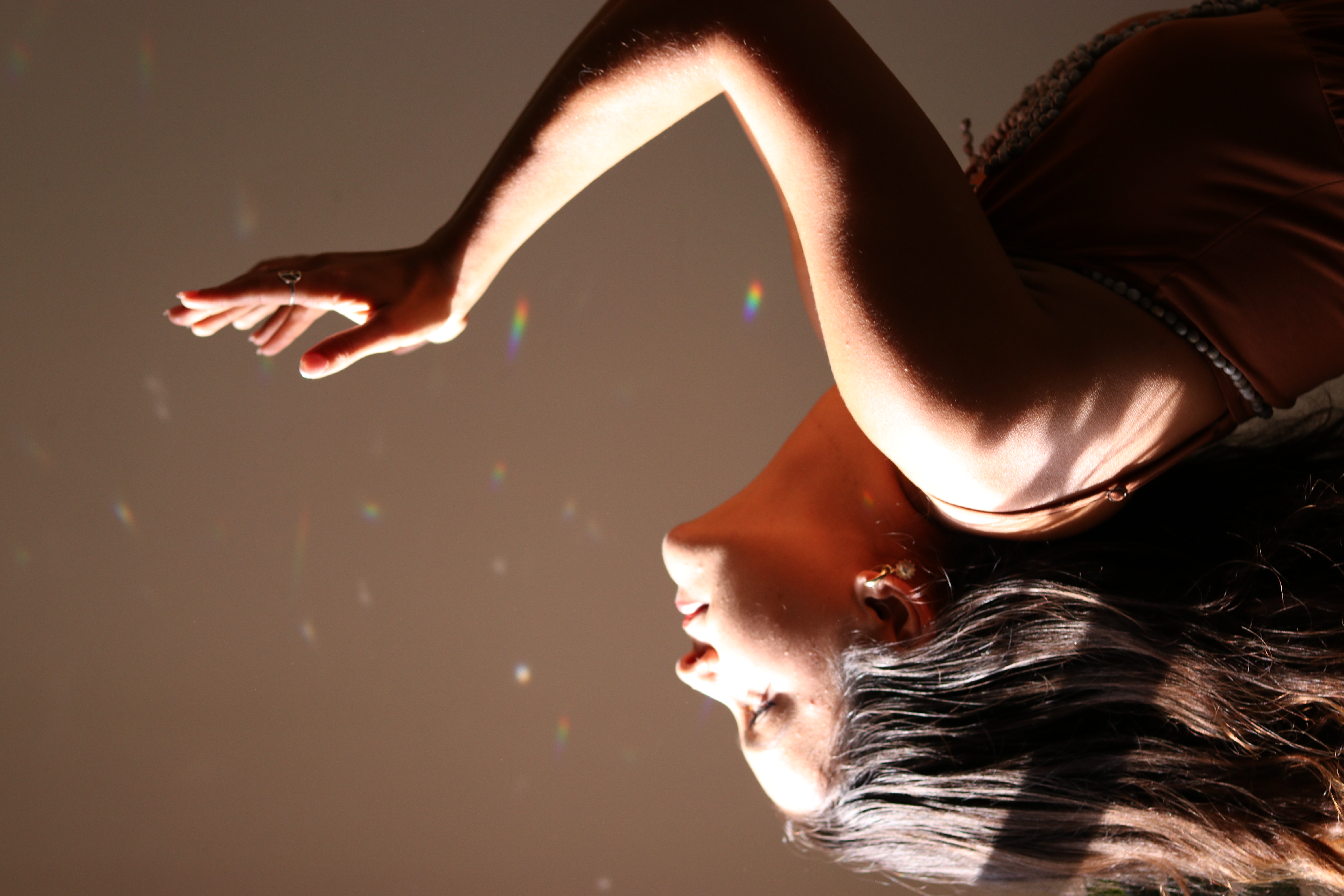 Madi reaching upward in soft window light