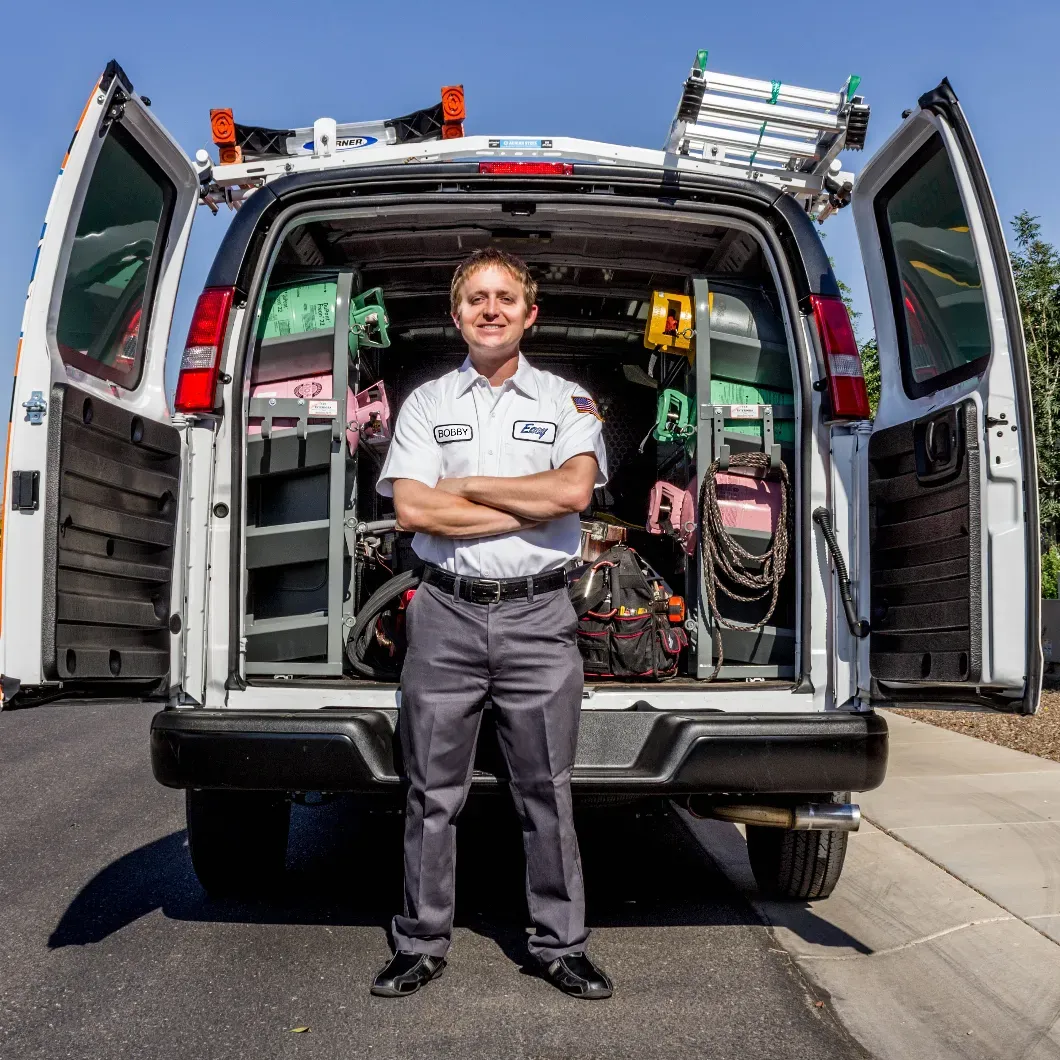 Maintenance specialist in front of service truck, ready to help a customer