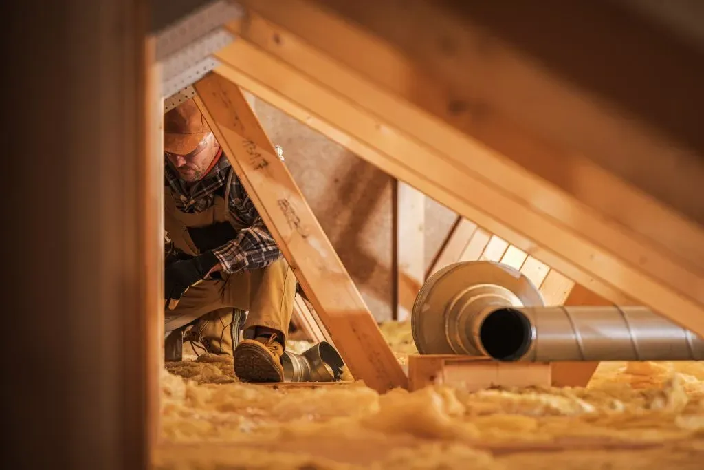 an expert roofer doing an Insulation on the attic