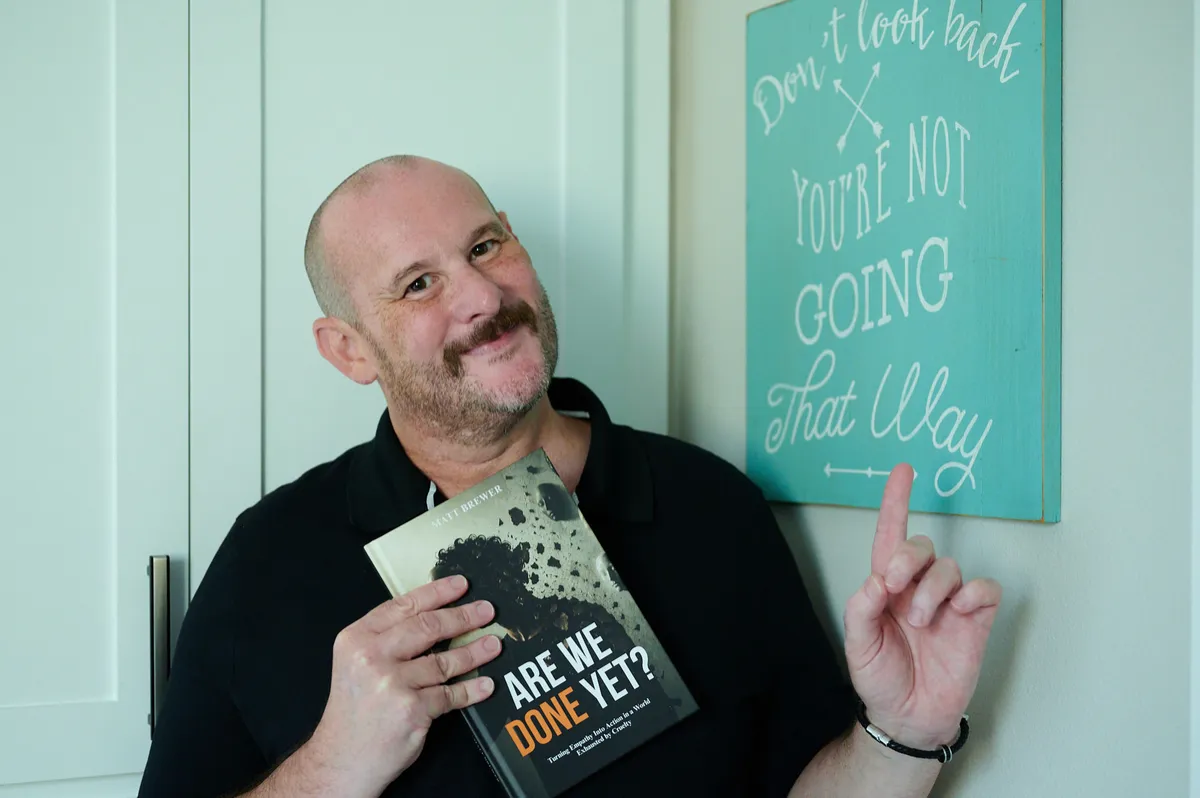 Matt Brewer holding the book Are We Done Yet?