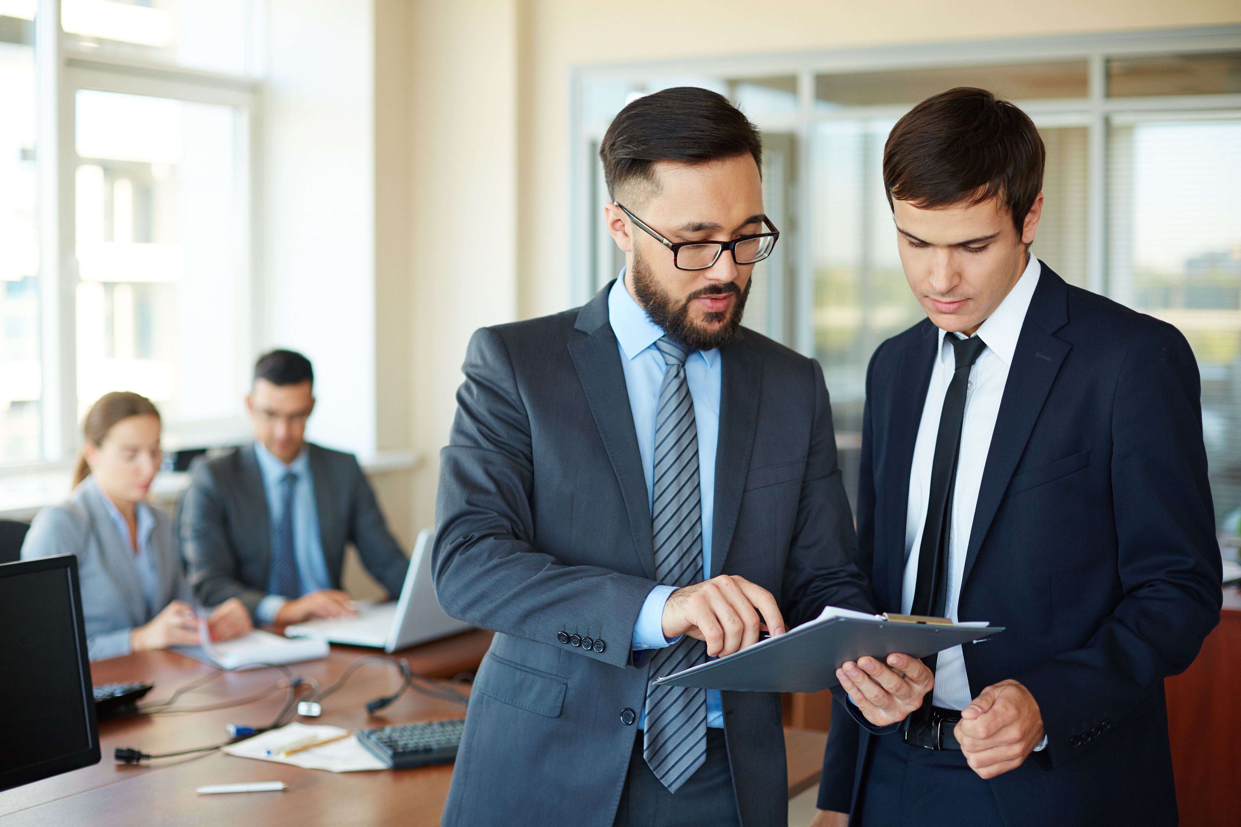 A female CPA and a male attorney, both in business attire, shaking hands across a conference table with a digital tablet between them. The office features modern decor, soft natural light, and subtle branding elements, symbolizing trust and partnership.