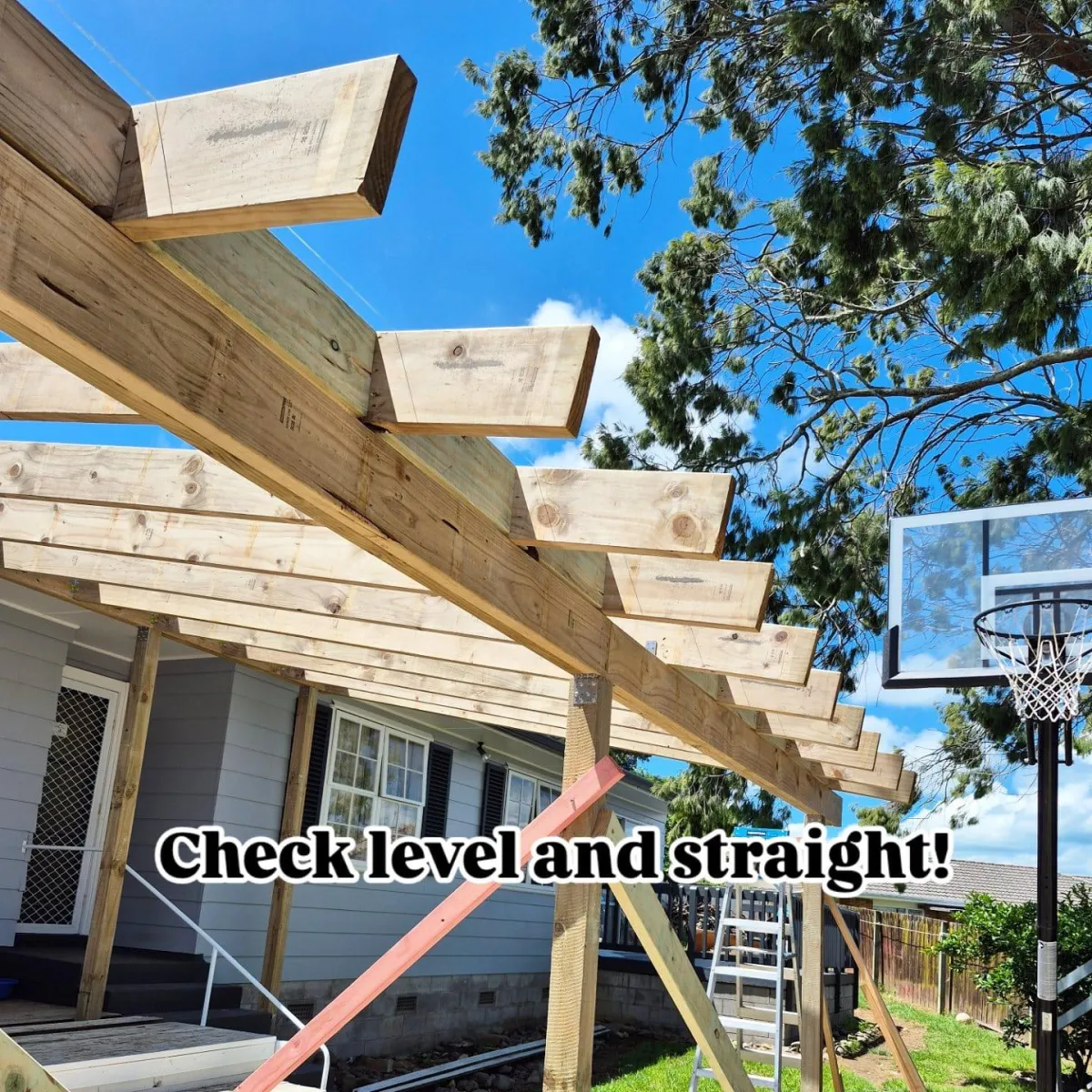 Timber deck frame under construction with a caption reading “Check level and straight!”, indicating the building process.