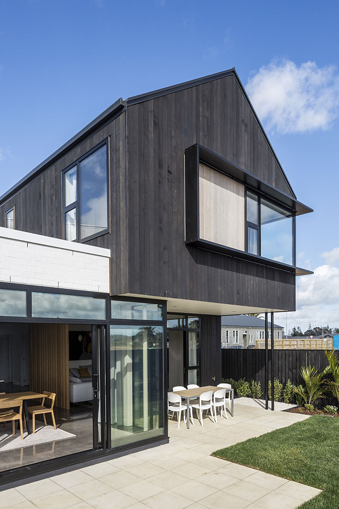 Modern two-storey residential home with a sleek white and grey exterior and timber fencing, representing new home construction.