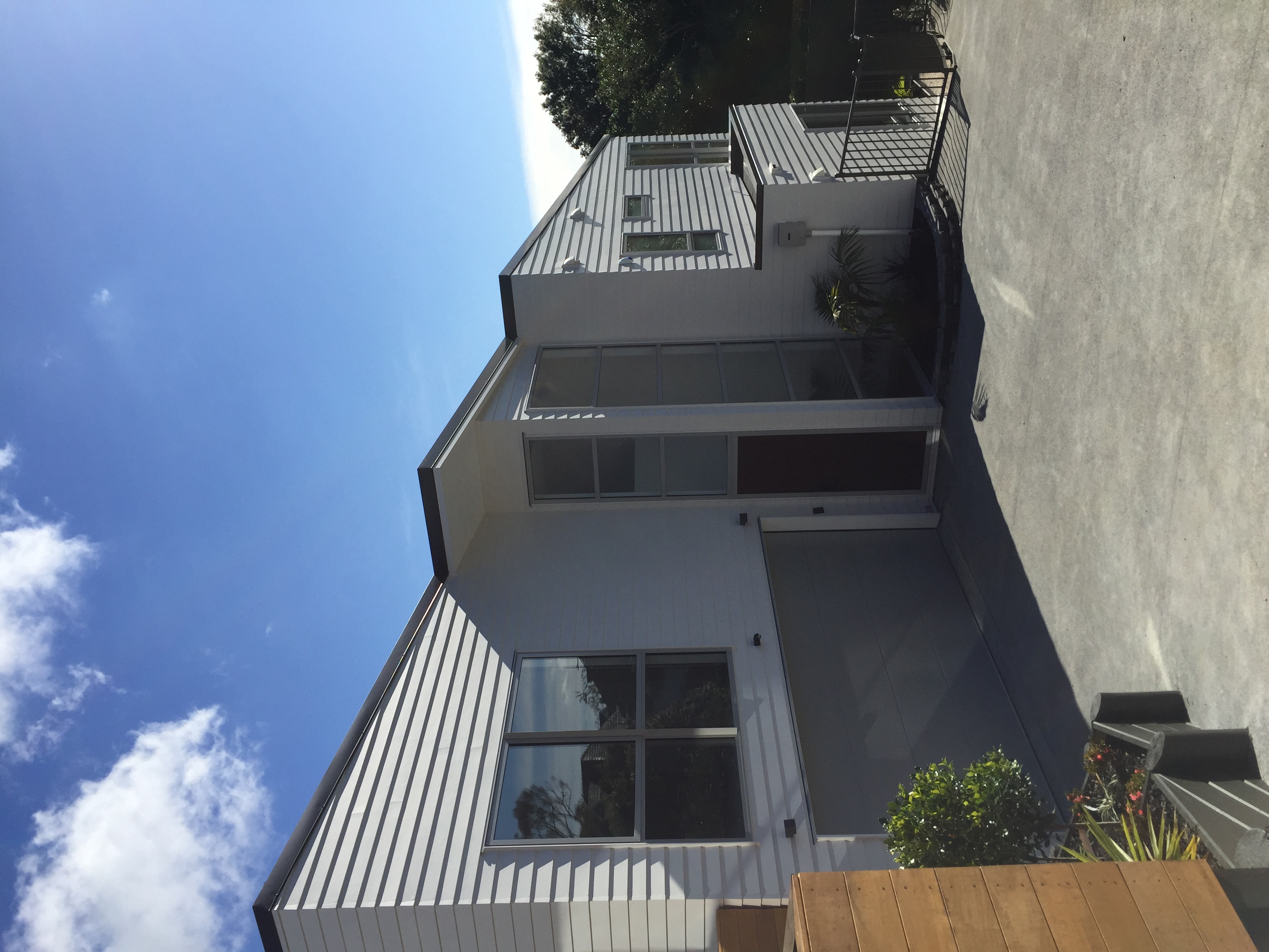 Contemporary open-plan living space with warm lighting and glass walls, showcasing stylish interior renovations.