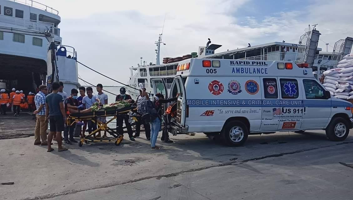 man in gray long sleeve shirt and black pants sitting on brown wooden floor