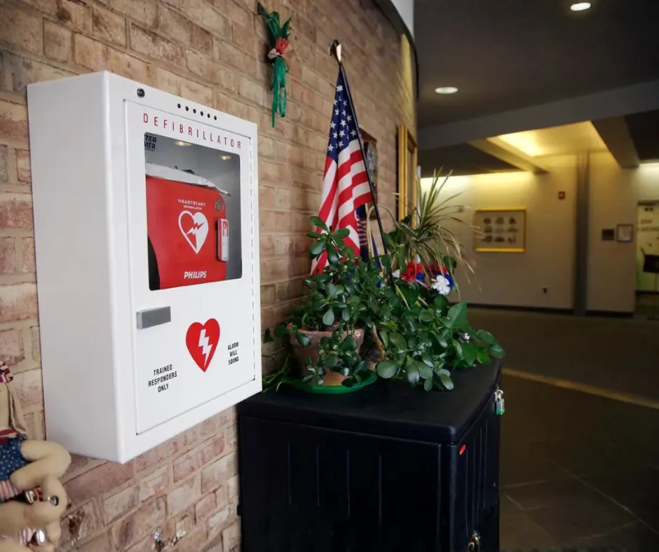 AED hanging on brick wall in a church lobby.