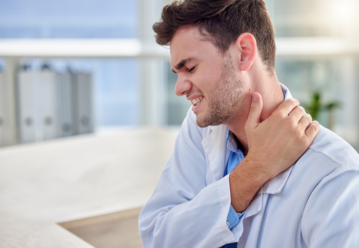 young man with neck pain at work