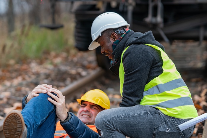Man helping his work friend who had an injury at work
