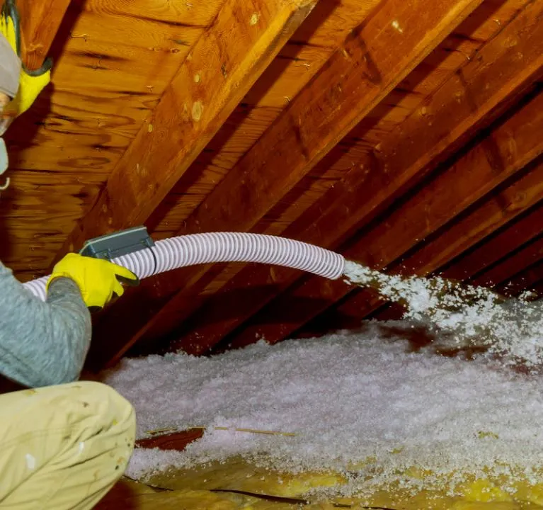 Worker applying blown-in insulation