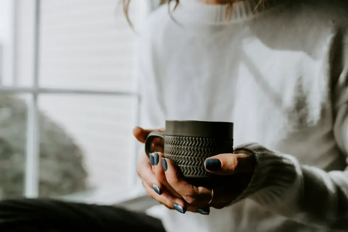 Contemplative woman thinking and holding coffee