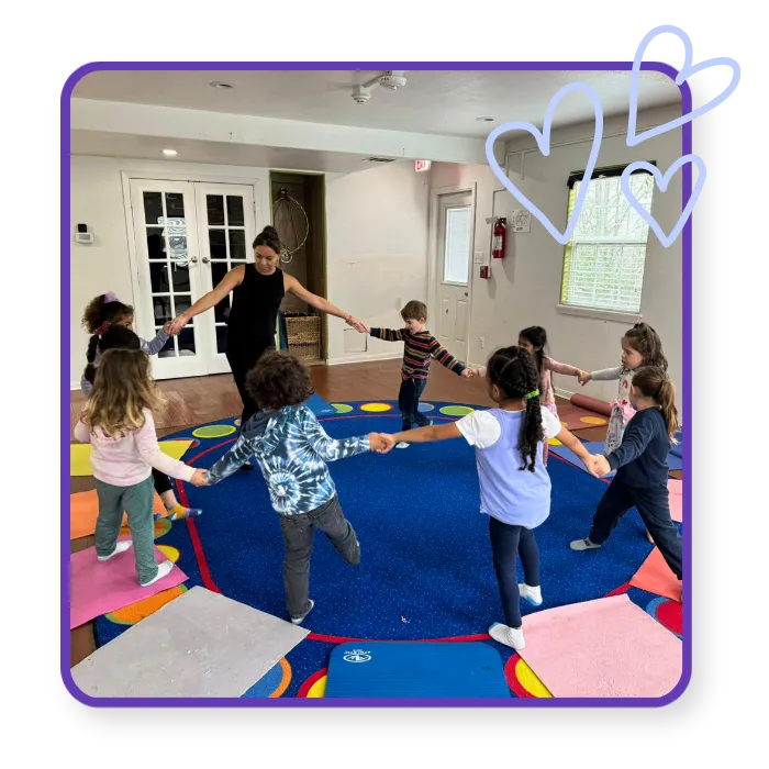 Children taking part in a teacher-led group movement activity at Blossoming Humans Spanish immersion preschool in Austin, Texas.