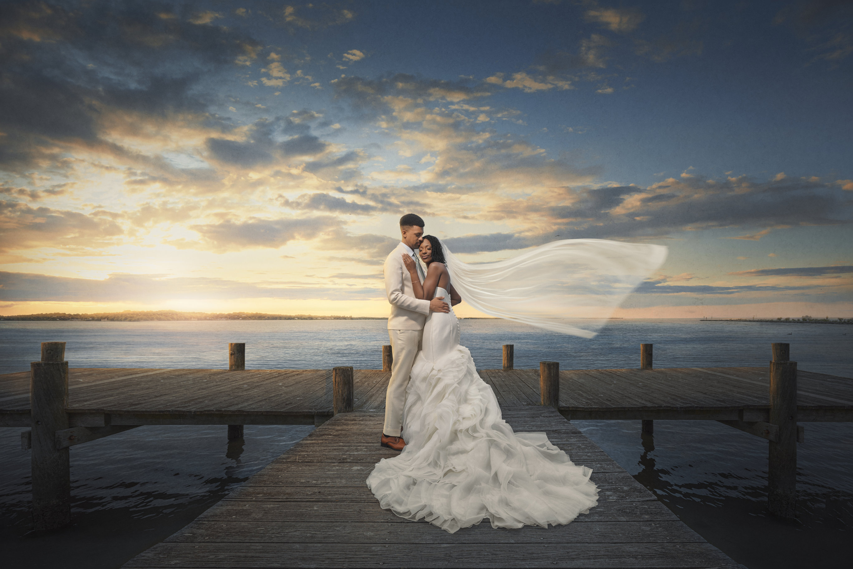 Bride and groom on a waterfront dock at sunset, photographed by Hunter Scott Imagery