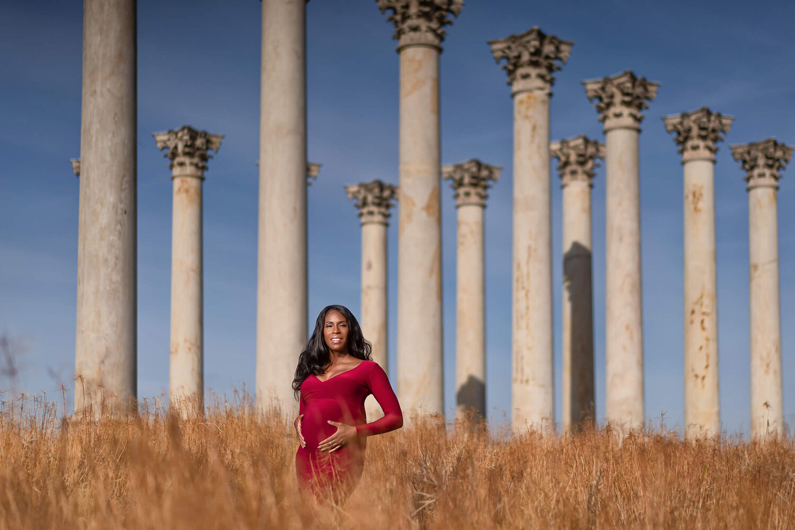 Washington D.C. maternity photography at the National Capitol Columns in a red gown