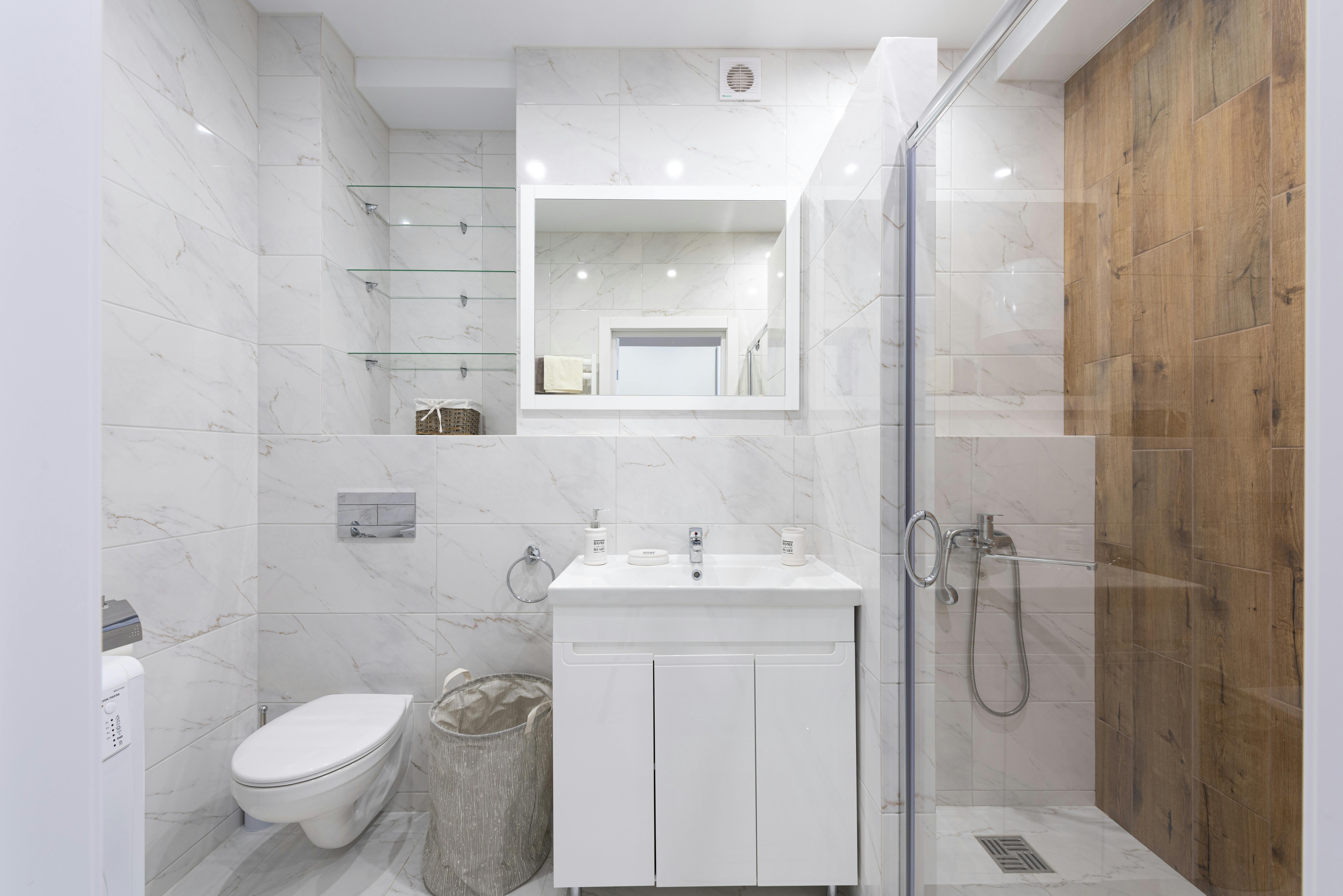 white narriow bathroom with shower toilet and sink