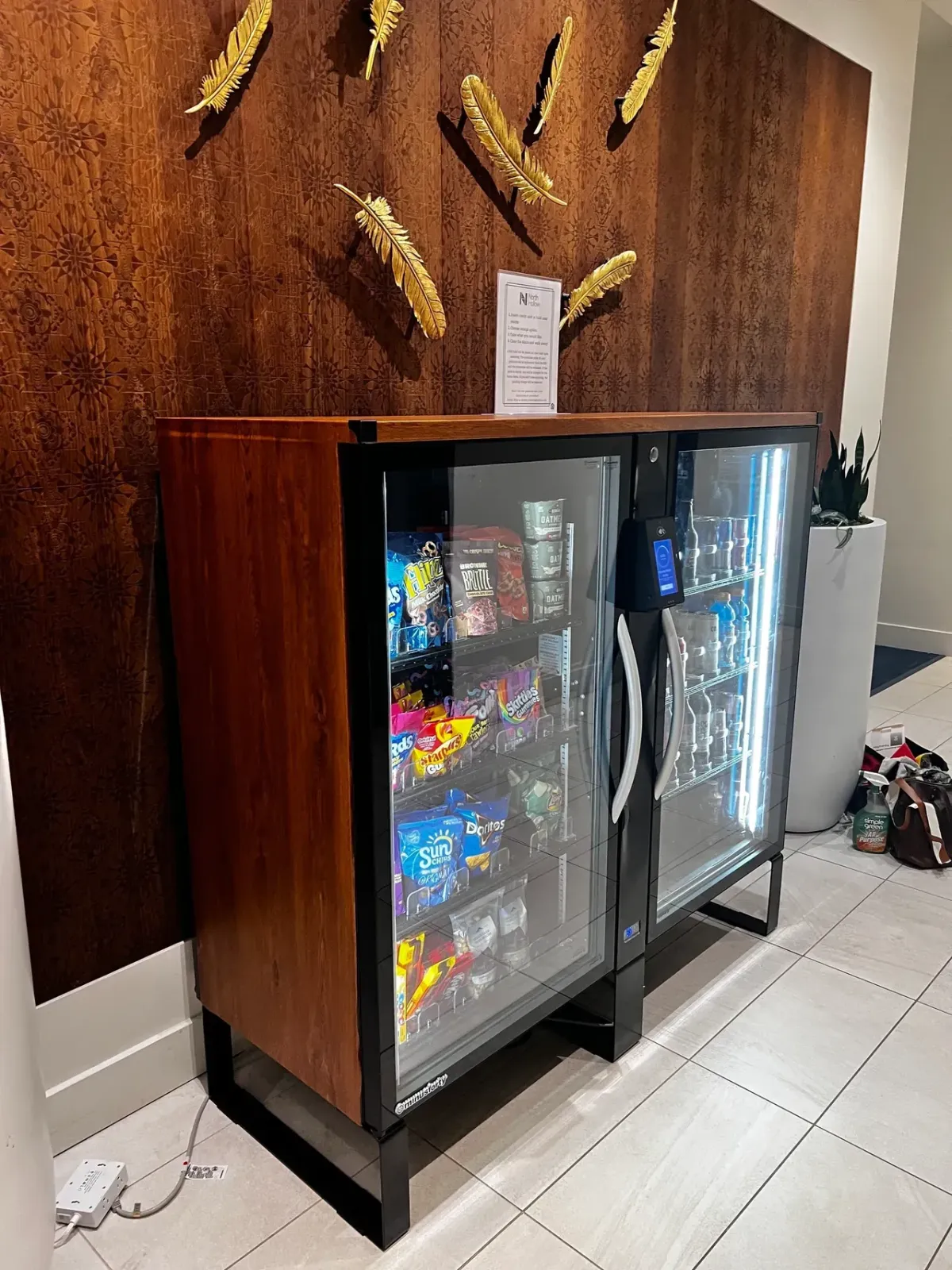 Woman selecting drink from illuminated vending machine