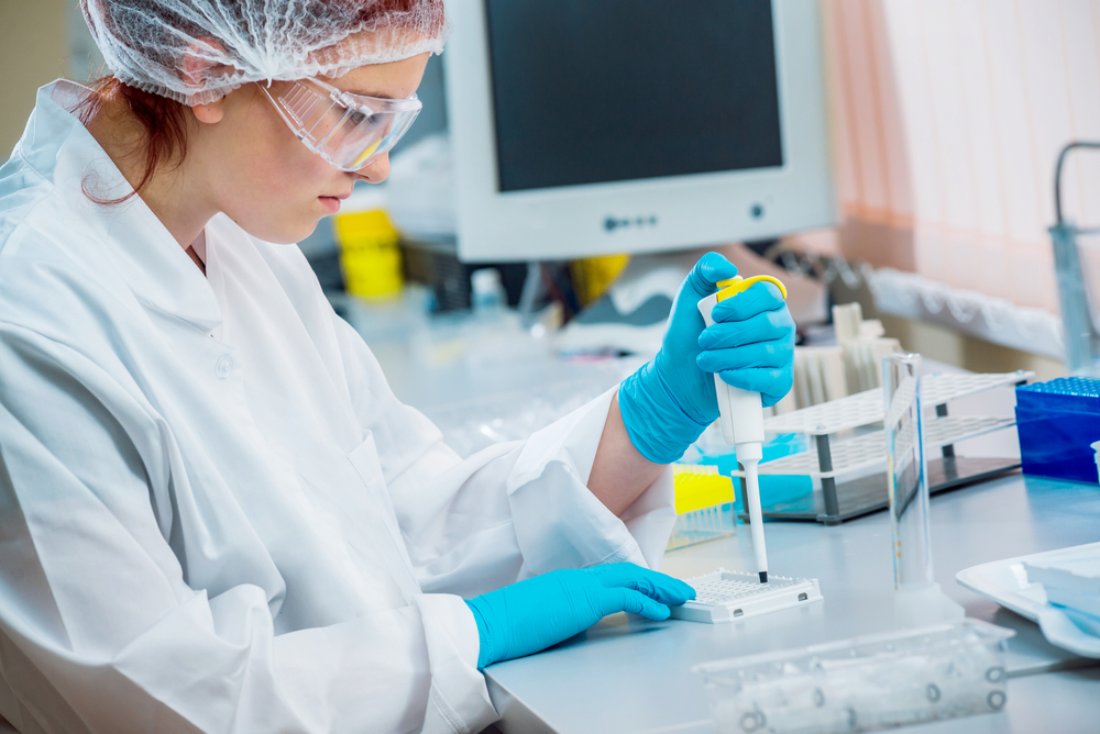 Two medical professionals in lab coats examine a test tube.