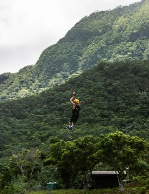 guy with yellow helmet ziplining in hawaii