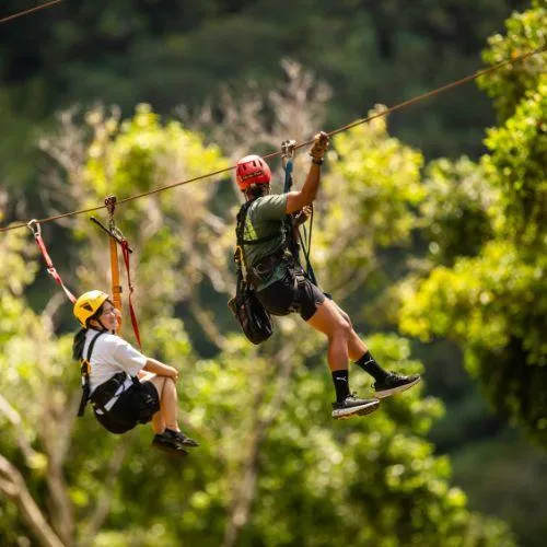 Guest zip lining with tour guide at Jurassic Valley Zipline