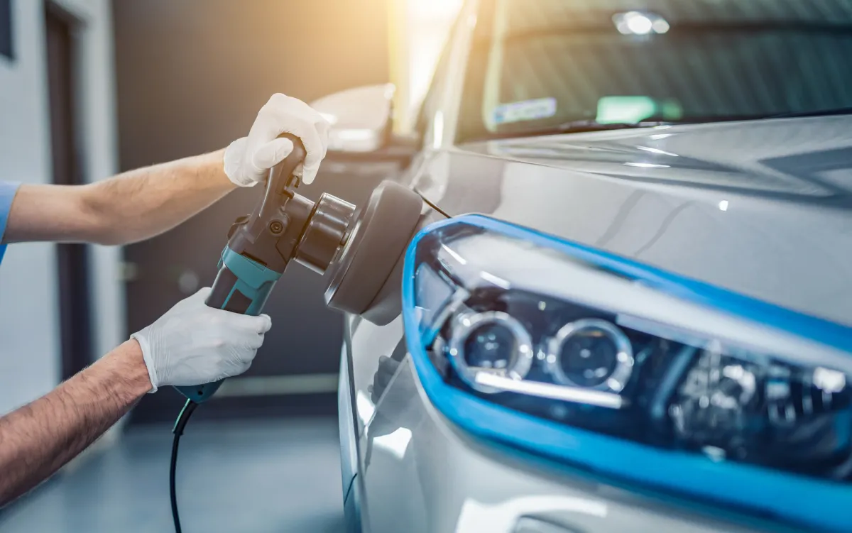 An individual spraying the interior of a car with a cleaning solution