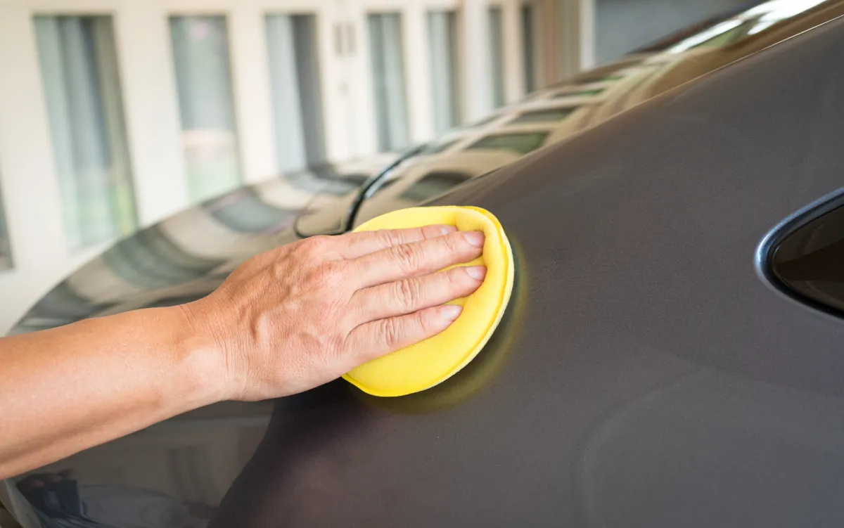 A man applying a ceramic coat on a car