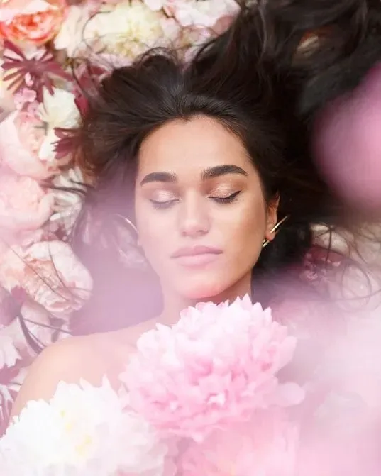 A pair of shoes and a purse on a bed