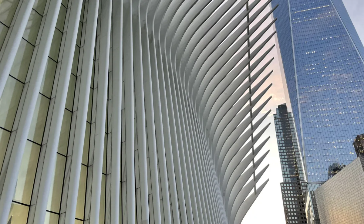A close-up of hands sketching user journey maps on paper, surrounded by sticky notes and digital devices, emphasizing empathy and thoughtful planning in a creative workspace.