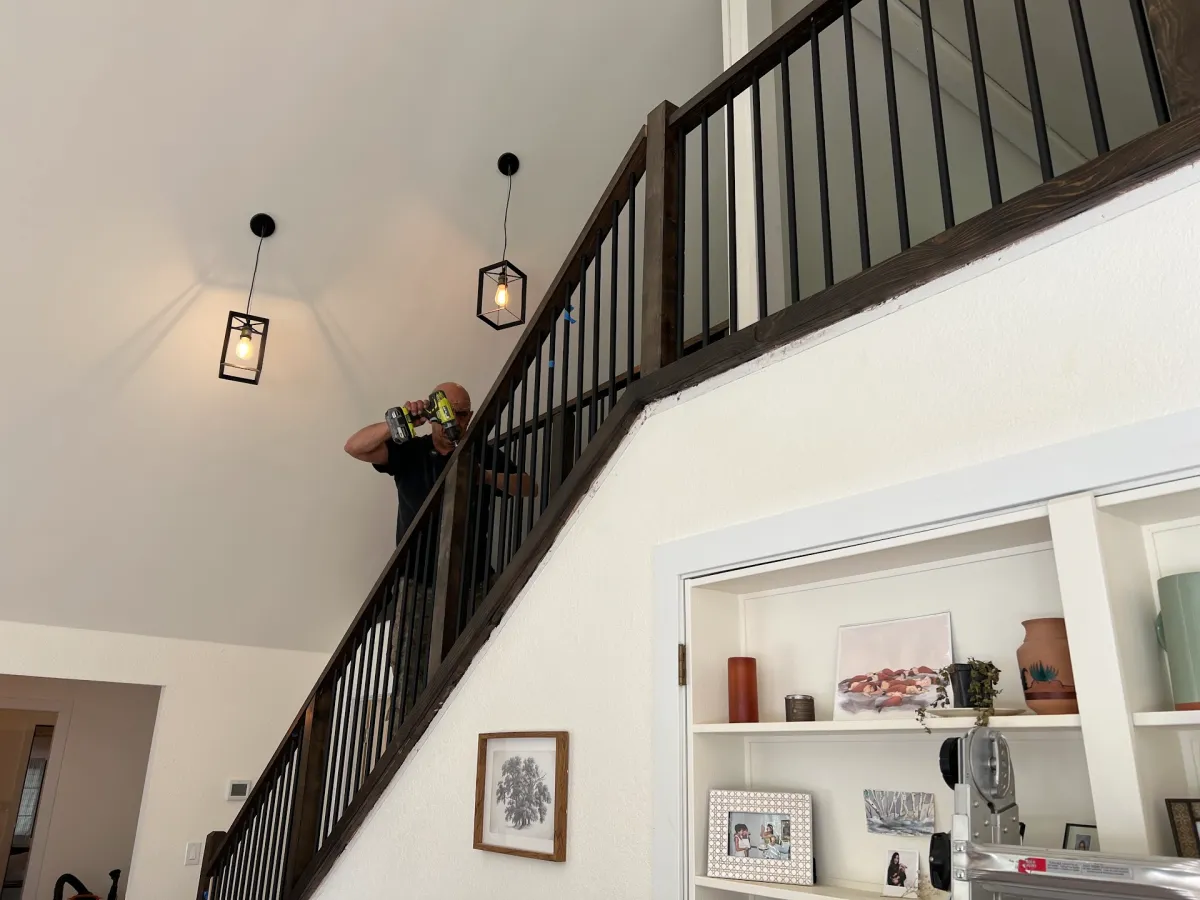 screwing down last handrail of custom stair railing install with stairs