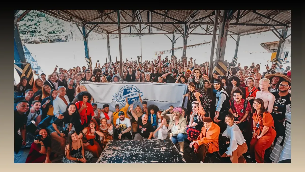 Grande photo de groupe de la Skyway Team réunie lors d’un événement international, avec une bannière portant le logo de l'équipe et des participants souriants venant du monde entier.