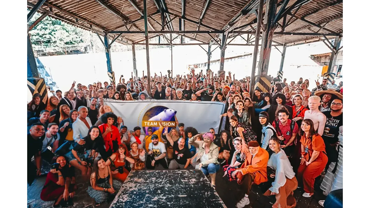 Gruppenfoto des Team Vision mit Hunderten von Teilnehmern bei einem inspirierenden Event. Das Team posiert vor einem großen Banner mit dem Eisbär-Logo – ein Symbol für Stärke, Zusammenhalt und gemeinsame Vision im Network Marketing.