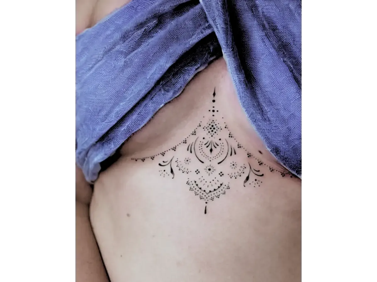 Tatouage ornemental sous la poitrine en style mandala délicat et féminin – Magic Tattoo Ink