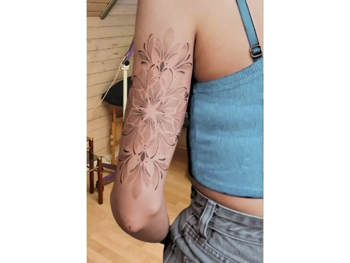 Tatouage floral géométrique noir et gris sur le bras d’une femme, motif mandala artistique et harmonieux – Magic Tattoo Ink