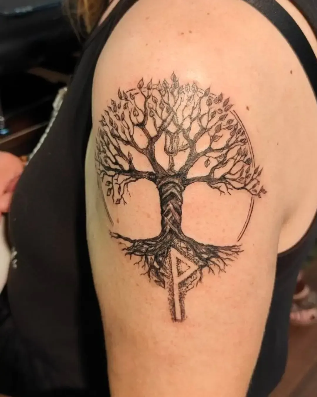 Tatouage arbre de vie avec racines et rune nordique – symbole de force, sagesse et connexion spirituelle, réalisé par Magic Ink à Fribourg.