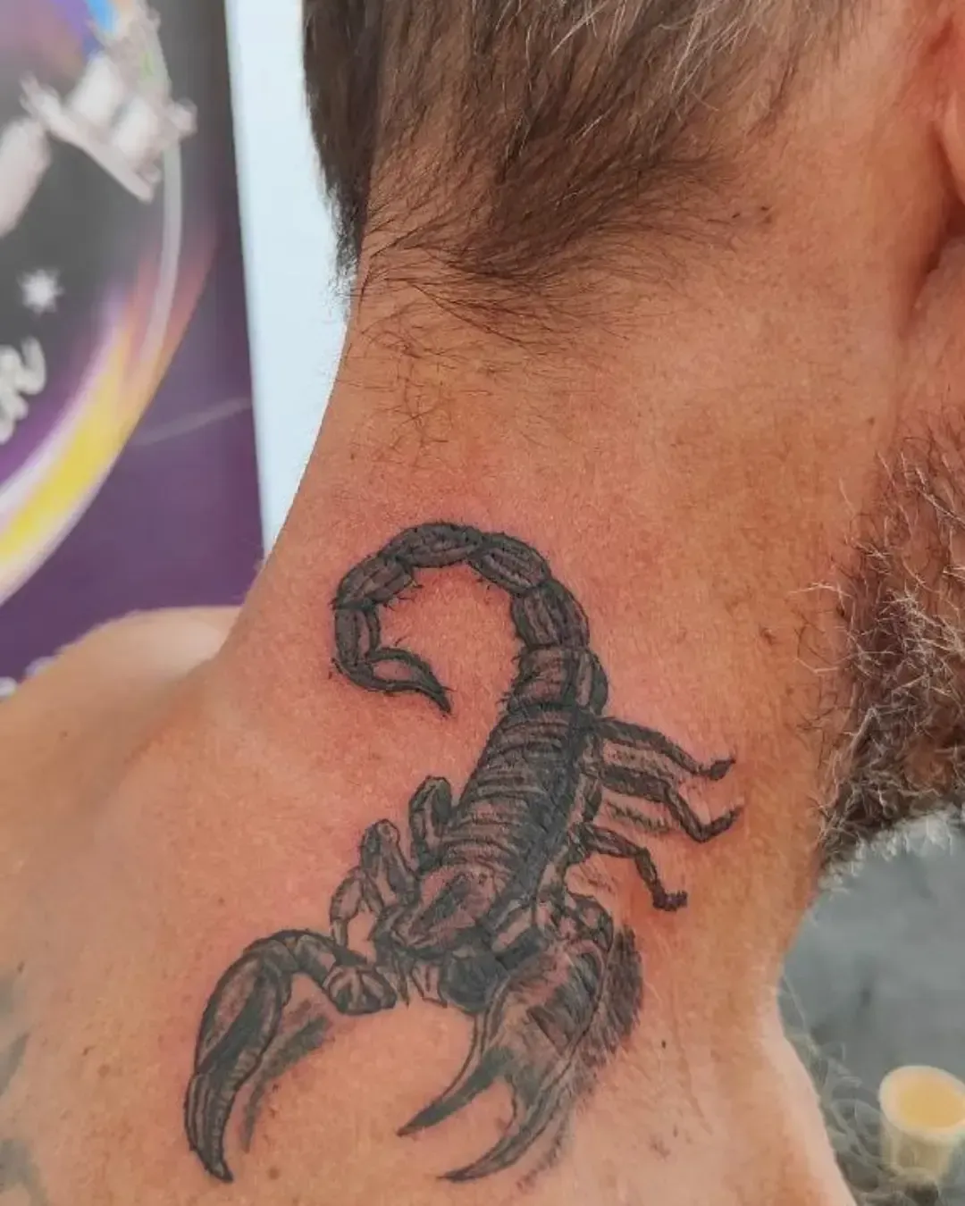 Tatouage d’un scorpion noir en détail, placé sur la nuque, symbole de force, de protection et de résilience. Les pinces et l’aiguillon relevé apportent une impression de puissance et de vigilance. Un choix fort et charismatique pour affirmer sa personnalité et son signe astrologique. Réalisé avec précision par Magic Tattoo Ink à Fribourg