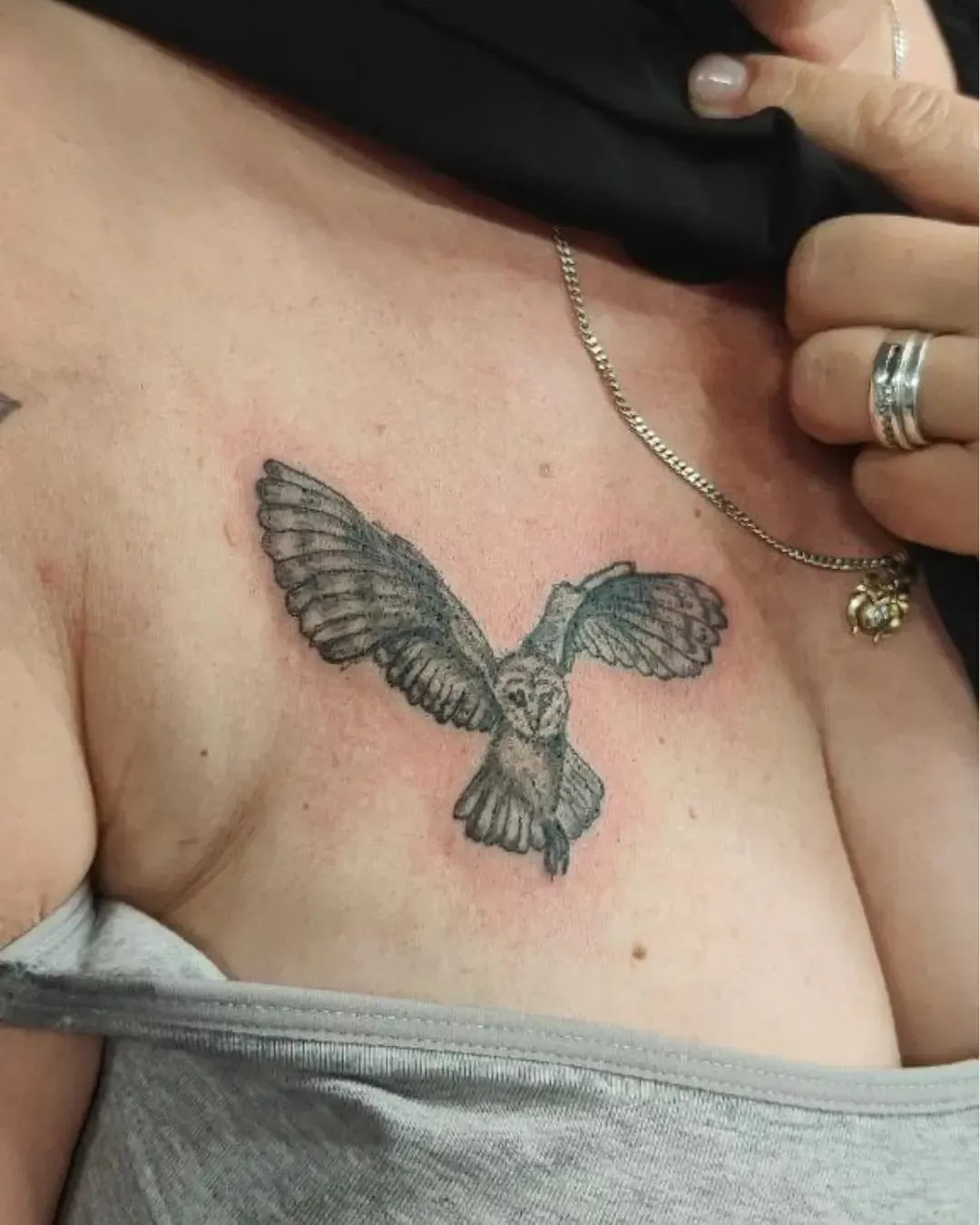 Tatouage réaliste de chouette en plein vol sur le torse – symbole de sagesse, intuition et liberté, réalisé par Magic Ink à Fribourg.